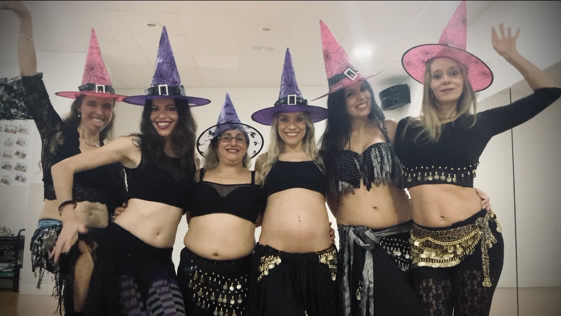 Grupo disfrazado celebrando Halloween con sombreros de bruja